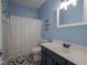 Cozy bathroom with blue walls, vanity sink, toilet, and shower with a patterned curtain at 7632 Nestucca Trl, Noblesville, IN 46062