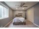 Gray bedroom with a rustic wood bed frame, ceiling fan, closet, and window at 7632 Nestucca Trl, Noblesville, IN 46062