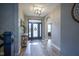 Hallway featuring wood floors, arched doorways, and a view of the front door and living room at 7632 Nestucca Trl, Noblesville, IN 46062