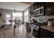 Modern kitchen with granite countertops, stainless steel appliances, and adjacent dining area at 7632 Nestucca Trl, Noblesville, IN 46062
