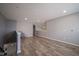 An upstairs living room with hardwood flooring and neutral-colored walls with staircase at 7632 Nestucca Trl, Noblesville, IN 46062