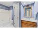 Traditional bathroom featuring a bathtub, white vanity, and a decorative mirror with a gold-colored frame at 774 Chapel Pines W Dr, Indianapolis, IN 46234