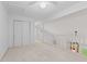 Bright loft area with white carpet, white walls, a closet, and a view of downstairs at 774 Chapel Pines W Dr, Indianapolis, IN 46234