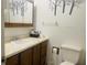 Functional bathroom featuring a vanity with storage, mirror, toilet, and decorative wall art at 7844 Partridge Rd, Southport, IN 46227
