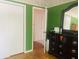 Bedroom view showing open door and closet, wood floors and green walls at 7844 Partridge Rd, Southport, IN 46227