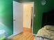 Bedroom view with green walls, open doorway, hardwood floor at 7844 Partridge Rd, Southport, IN 46227