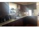 A functional kitchen is equipped with wooden cabinets, a sink, and laminate countertops at 7844 Partridge Rd, Southport, IN 46227