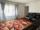 Bright living room featuring a comfortable leather sectional sofa, hardwood floors, and sheer curtains at 7844 Partridge Rd, Southport, IN 46227
