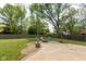 Backyard featuring a concrete patio with a fire pit, surrounded by lush greenery at 8415 Los Robles Rd, Fishers, IN 46038