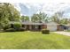 Charming brick ranch-style home with a well-manicured lawn and mature trees at 8415 Los Robles Rd, Fishers, IN 46038