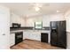 Bright kitchen featuring white cabinets, tile backsplash, and modern black appliances at 8415 Los Robles Rd, Fishers, IN 46038