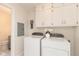 Convenient laundry area featuring white cabinets and appliances next to a bathroom at 8415 Los Robles Rd, Fishers, IN 46038