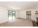 Inviting living room space with neutral carpet, access to backyard, and fireplace at 8415 Los Robles Rd, Fishers, IN 46038