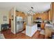 Kitchen area featuring an island, stainless steel refrigerator, and wooden cabinets at 8745 Providence Dr, Fishers, IN 46038
