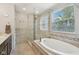 Luxurious main bathroom with soaking tub, tiled shower, and bright natural light at 8745 Providence Dr, Fishers, IN 46038