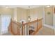Upstairs landing with chandelier, plush carpet, and light-filled stairway at 8745 Providence Dr, Fishers, IN 46038