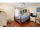 Bedroom with metal frame bed, hardwood floors, light colored walls, and ceiling fan at 9915 Wellsford Cir, Indianapolis, IN 46236