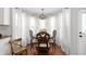 Inviting dining area featuring a round table, chairs, and large windows with curtains at 9915 Wellsford Cir, Indianapolis, IN 46236