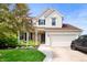 Charming two-story home with a brick and siding exterior, attached two-car garage, and well-maintained landscaping at 9915 Wellsford Cir, Indianapolis, IN 46236