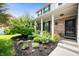 Inviting covered front porch with brick accents, stylish door, and lush landscaping at 9915 Wellsford Cir, Indianapolis, IN 46236