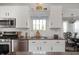 Well-equipped kitchen featuring white cabinets, stainless steel appliances, and a view to the dining area at 9915 Wellsford Cir, Indianapolis, IN 46236