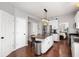 Open kitchen with white cabinets, stainless steel appliances, granite counters, and hardwood floors at 9915 Wellsford Cir, Indianapolis, IN 46236