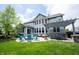 Backyard featuring a patio with a fire pit, seating, hot tub, and a well-manicured lawn at 10291 Normandy Way, Fishers, IN 46040
