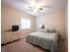 Neutral bedroom with a ceiling fan, window, dresser with a TV, and a comfortable bed with blue accents at 10291 Normandy Way, Fishers, IN 46040