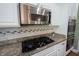 Updated kitchen with granite counters, stainless appliances, tiled backsplash, and gas cooktop beneath a stainless microwave at 10291 Normandy Way, Fishers, IN 46040