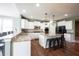 Bright kitchen features white cabinets, granite countertops, stainless steel appliances, and an island with barstool seating at 10291 Normandy Way, Fishers, IN 46040