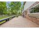 The home's backyard features a wooden deck and red brick exterior partially surrounded by lush greenery at 10429 Lasalle Rd, Carmel, IN 46033