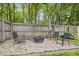 Outdoor firepit area with chairs, a wooden fence and mature trees around the property's perimeter at 10429 Lasalle Rd, Carmel, IN 46033