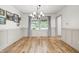 Bright dining room with hardwood floors, stylish chandelier, and decorative wainscoting for an elegant dining experience at 10429 Lasalle Rd, Carmel, IN 46033