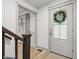 Bright foyer with wood floors, a staircase, and a white front door with wreath at 10429 Lasalle Rd, Carmel, IN 46033