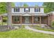 Inviting brick-clad porch with rocking chairs, wood columns and views to the lawn at 10429 Lasalle Rd, Carmel, IN 46033