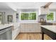 Open kitchen with wood floors, farmhouse sink, stainless appliances, and a large window at 10429 Lasalle Rd, Carmel, IN 46033
