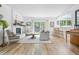 Open-concept living room with wood floors, fireplace, and access to the backyard at 10429 Lasalle Rd, Carmel, IN 46033
