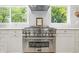 Close up of stainless steel oven and vent hood with light gray backsplash and natural light at 10429 Lasalle Rd, Carmel, IN 46033