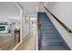 The staircase features updated wood handrails and blue-painted stairs. It leads to the main floor with hardwood floors at 10429 Lasalle Rd, Carmel, IN 46033