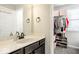 Well-lit bathroom with a white vanity, marble countertop, and adjacent closet at 1050 Windsor Estates Ct, Westfield, IN 46074