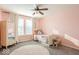 Bright bedroom features a ceiling fan, neutral curtains, and plush carpet flooring at 1050 Windsor Estates Ct, Westfield, IN 46074