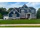 Beautiful two-story home featuring stone accents, a well-manicured lawn, and a classic blue facade at 1050 Windsor Estates Ct, Westfield, IN 46074
