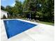 In-ground pool surrounded by lounge chairs and landscaping in this backyard oasis at 1050 Windsor Estates Ct, Westfield, IN 46074