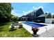 An in-ground pool with a hot tub surrounded by comfortable lounge furniture sits in a well-maintained backyard at 1050 Windsor Estates Ct, Westfield, IN 46074