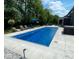 An in-ground pool surrounded by lounge chairs sits alongside a hot tub in this backyard retreat at 1050 Windsor Estates Ct, Westfield, IN 46074