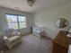 Sunlit bedroom with a crib, chair, and dresser offers a cozy space at 11163 Autumn Harvest Dr, Fishers, IN 46038