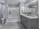Modern bathroom with a double vanity, gray cabinets, and a glass-enclosed shower at 1119 Albemarle Cir, Noblesville, IN 46062