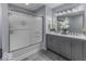 Modern bathroom with a double vanity, gray cabinets, and a glass-enclosed shower at 1119 Albemarle Cir, Noblesville, IN 46062