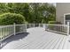 A spacious gray deck with white railings offers a serene view of the well-manicured backyard at 1119 Albemarle Cir, Noblesville, IN 46062
