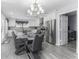 Bright dining room with modern chandelier, gray flooring, and stainless-steel appliances at 1119 Albemarle Cir, Noblesville, IN 46062